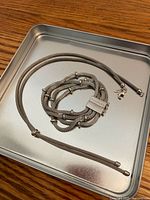 Bracelet coiled and necklace laid flat on tray showing overall design