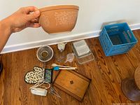 Lot overview with Pyrex mixing bowl held and other items on floor