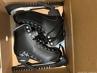 Pair of black Bladerunner Aurora figure skates displayed in a cardboard box showing top and side views.