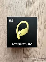 Box of yellow PowerBeats Pro wireless earphones, shows sweat and water resistant label
