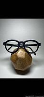 Front view of blue designer glasses showing rectangular lenses and distressed wood texture frame.