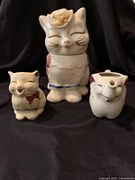 Front view of the three ceramic pieces: the Puss ‘n’ Boots cookie jar, the cat creamer, and the elephant creamer, showing condition and design details.