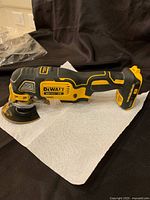 Side profile of tool lying on paper towel showing body shape, grip, and installed blade