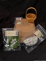 Overall lot including basket, box, floral arrangement, liner, and tie-on accessory