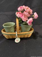 Longaberger miniature Peony Basket with two green pottery flower pots inside and a pink peony floral arrangement inserted into one pot