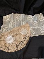 Set of 4 lace and linen textile items including rectangular white linen and three round lace doilies.