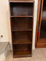 Full view of the wooden bookshelf showing four shelves and overall shape.