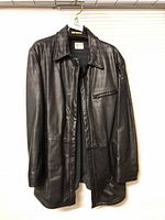 Full view of black leather coat hanging showing overall condition and style