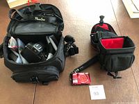 Lot overview showing Canon camera in case, Nikon camera and empty case