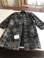 Full view of the Eileen Fisher ladies jacket showing its shape and pattern.