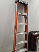 Industrial Lite 6-foot step ladder view front with orange frame, aluminum steps and wear.