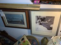 Photo showing two framed Robert Bateman prints, one depicting waterfowl on a lake and the other showing a river and animals in snow.