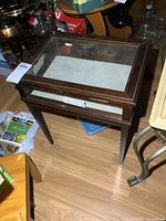 Top view showing glass lid and wooden frame of the display table with some wear on the interior base.