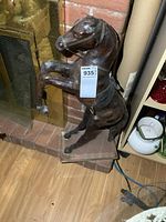 Front and side angled view of large leather horse sculpture showing details of leather texture and horse's rearing pose on clear acrylic base, from photo 1.