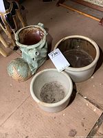 View of the three planters: large stoneware crock, smaller stoneware crock, and green ceramic boot planter with decorative details.