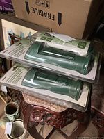 Two Woods power post timers stacked on top of each other in original plastic packaging, showing the front and side views with timer control features visible.