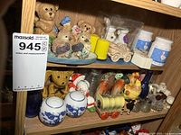 Two shelves filled with a variety of decorative salt and pepper shakers of various designs including bears, birds, animals, and novelty shapes.