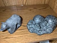 Photo showing a bear sculpture and an igloos scene sculpture on wooden shelf.