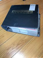 Thick black binder labeled 'Collectors Album' contains large collection of sports cards, shows wear on edges.