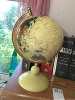 Photo showing the full globe, ivory base, and brass meridian frame with geographic markings including North Pacific and Australia region.