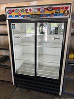 Front view showing overall condition, double glass doors, sticker decorations