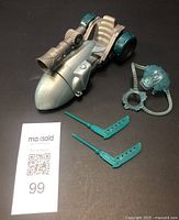 Front and side view of Mr. Freeze Dragster with two teal blades and ice accessory on dark background with MaxSold tag.