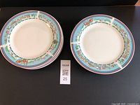 Side view of stack of ten Christmas dinner plates with colorful holiday scene border