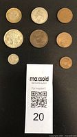 Seven circulated coins from Britain and Ireland with a MaxSold auction support slip