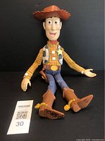 Front view of 16-inch tall Woody doll seated with arms open and legs extended, showing full outfit and facial details.