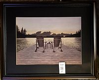 Framed print showing two Adirondack chairs and small table on dock by lake at sunset.