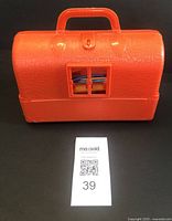 Orange vintage plastic medical bag, cracked surface, handle, with missing part on front