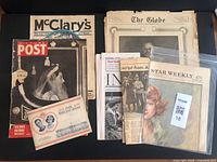 A collection of various old newspapers, magazines, articles, and a souvenir booklet commemorating King George VI's coronation, laid out flat.