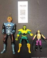 Front view of three vintage action figures on dark surface with MaxSold label; shows Symbion Dargon, G.I. Joe Dr. Mindbender, and Iron Man Mandarin.