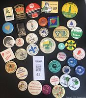 Top side of 38 vintage charity and awareness buttons showing colorful fronts with various causes and years, including cancer awareness, youth year, anti-smoking, nurses, and Canadian pride.
