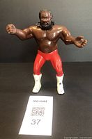 Front view of the Junkyard Dog figure standing showing its red pants and white boots with black stars, and the detailed molded hair and beard.
