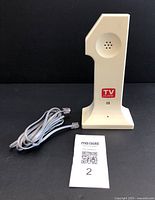 Front view of vintage TV Guide telephone in beige plastic with included cord and MaxSold tag.