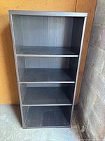 Photo of black 4 shelf bookcase, showing four shelves and wood finish