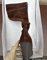 Side profile of dark brown suede Calvin Klein boot showing slouchy mid-calf shaft and high block heel.