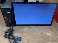 Gateway desktop tower and monitor side by side with VGA cable displayed on surface in front