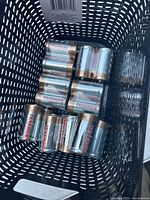 Top-down photo of eight new Tenergy D size batteries arranged in a black plastic container.