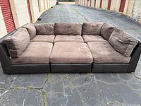 Front view of the mocha sectional couch showing cushioned seats and backrests with minor visible wear.