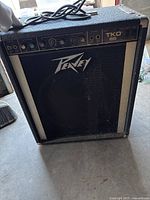 Front view of the Peavey TKO 65 amplifier showing control panel, speaker grille with logo, and cabinet condition.