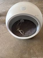 Front view of white Petkit Cozy pet bed with inscription 'Petkit' and 'Cozy' badge on top, power cord and heated pad inside