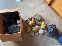 Box containing various reptile habitat accessories including power adapters and other items partly visible in the box.