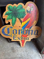 Front view of the wooden sign featuring the Corona Extra logo, colorful parrot, and palm tree