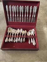 Full view of the open wooden case containing the vintage silver plated flatware set including knives, forks, spoons, smaller spoons, and serving utensils.