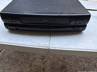 Front view of a black Zenith VCR with model number VCR4125 showing buttons and tape slot.