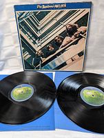 Front of gatefold album cover with blue border and upward stairwell photo