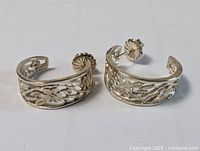pair of sterling silver floral hoop earrings front view