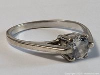 Side view of sterling silver ring showing prong-set round diamond